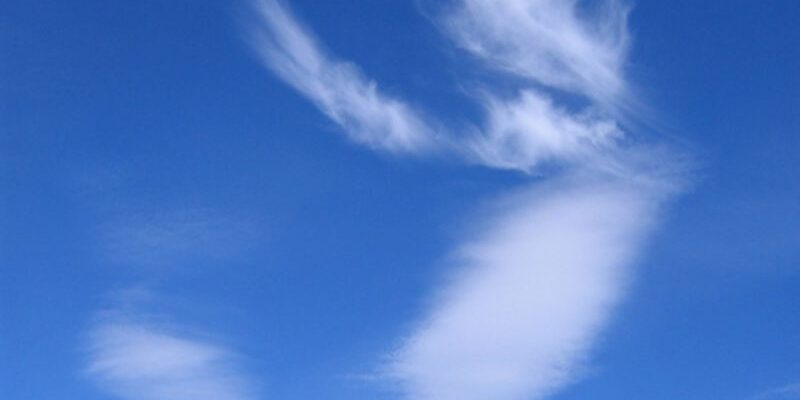 Wispy white clouds against a bright blue sky, resembling abstract shapes.