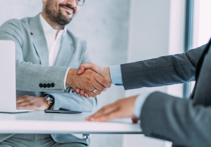 Shot of two businessmen shaking hands in the office.