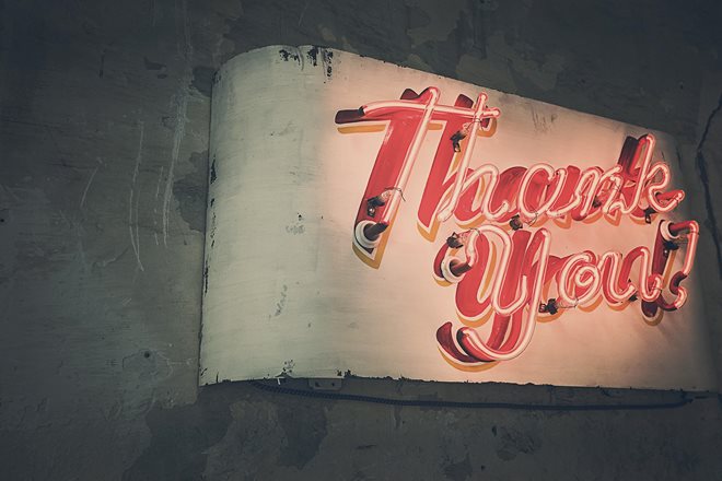 celebratingsmallbusinesses.jpg A vintage neon sign mounted on a worn wall displays the words “Thank You” in red script.