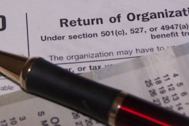 tax-form-photo-1200x800.jpg A pen rests on tax documents, including a form related to section 501(c) for business entities and organizations.